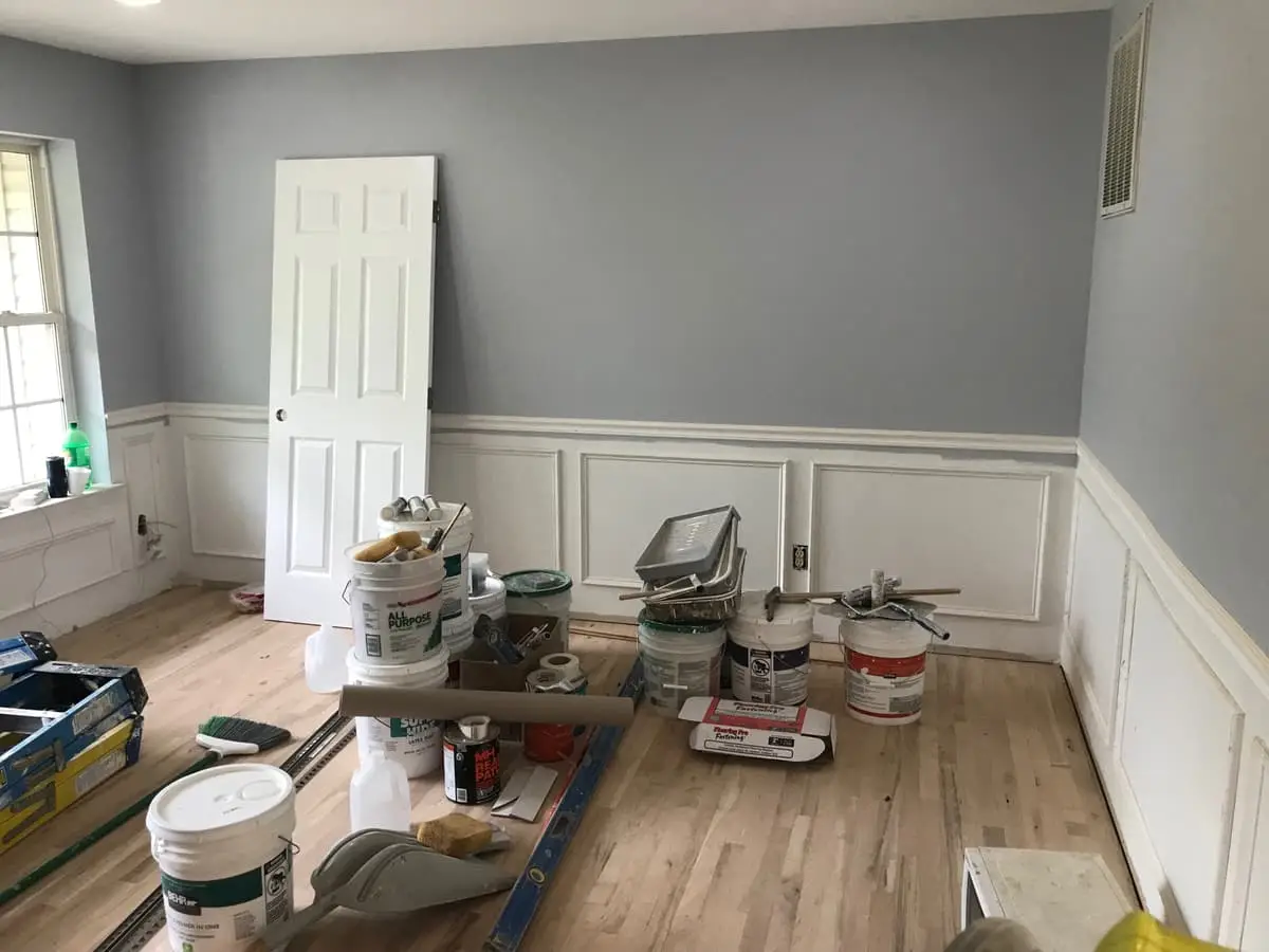 Selling a house with code violations in Islip: dining room mid-renovation with new wainscoting and paint cans