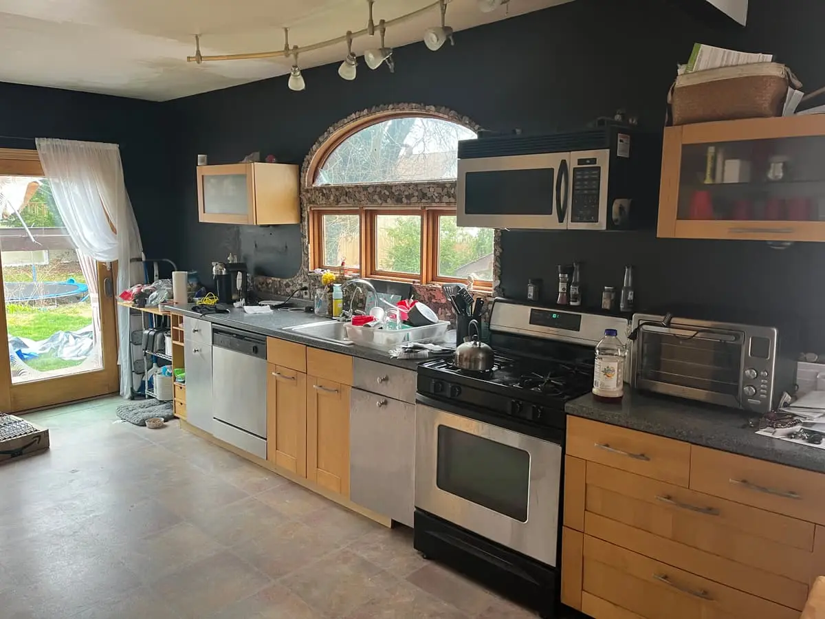 Selling without a realtor in Islip: occupied kitchen with an arched window and crowded counters