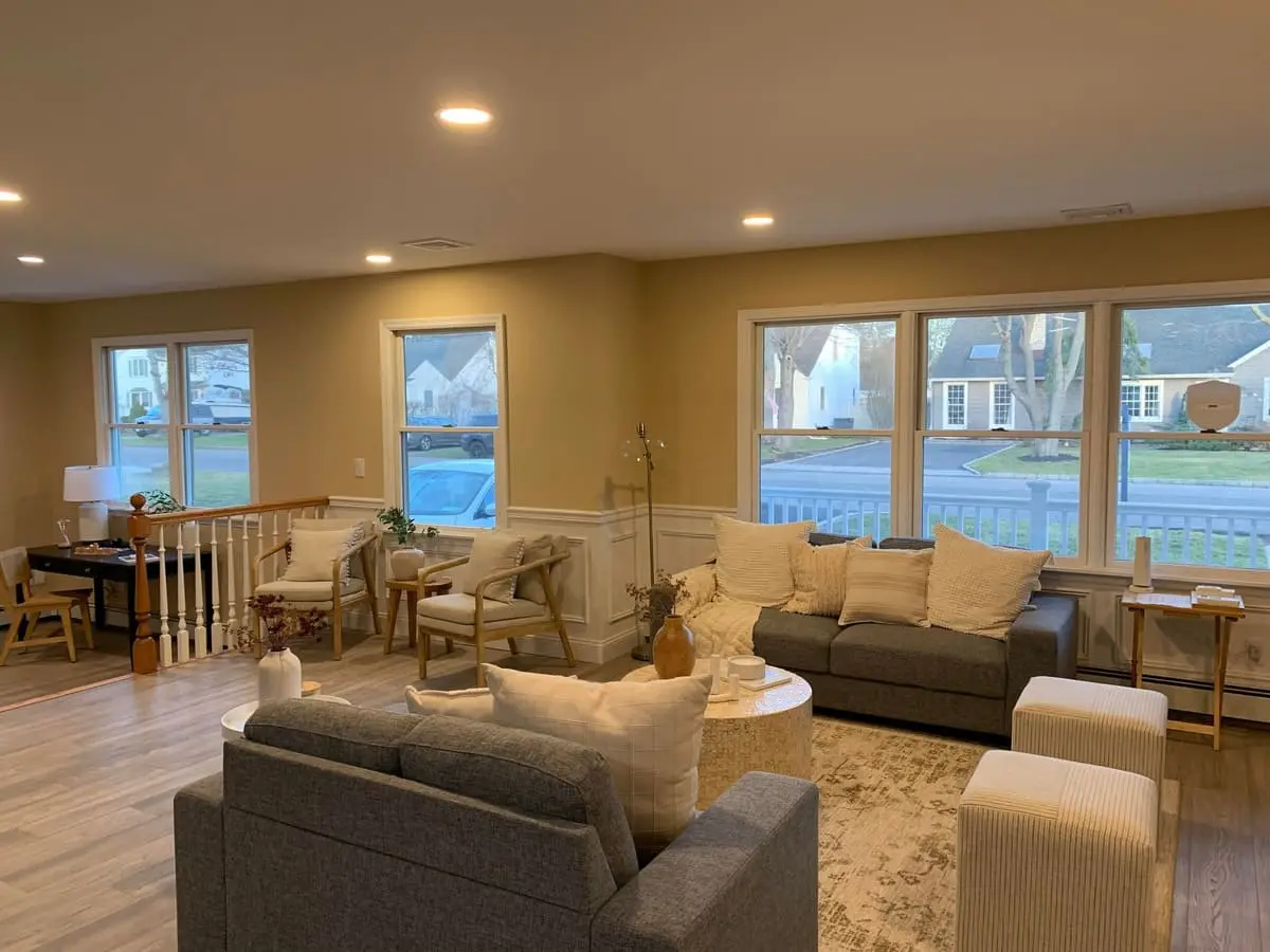 Selling a house after a life change in Islip: renovated open living room with new plank floors and wainscoting
