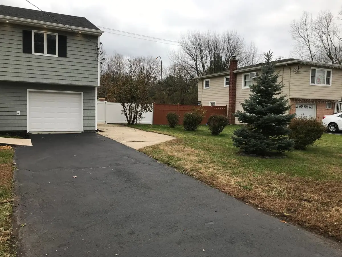 Selling a house in pre-foreclosure in Islip: renovated raised ranch with gray siding and a new driveway