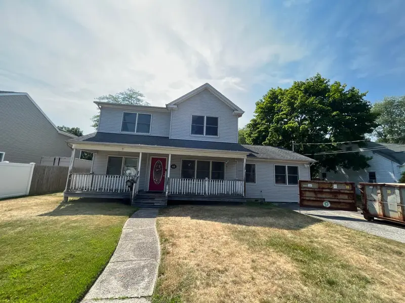 Two-story colonial with a covered front porch and a long front walk, Islip, NY